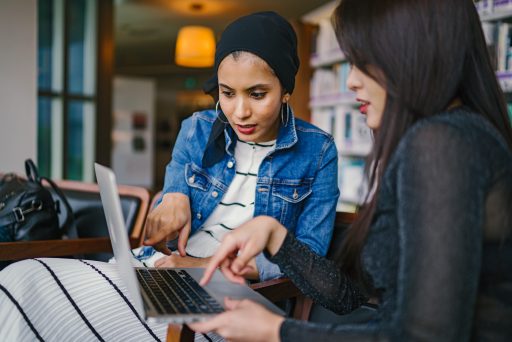 Dos mujeres mirando una pantalla de ordenador y debatiendo